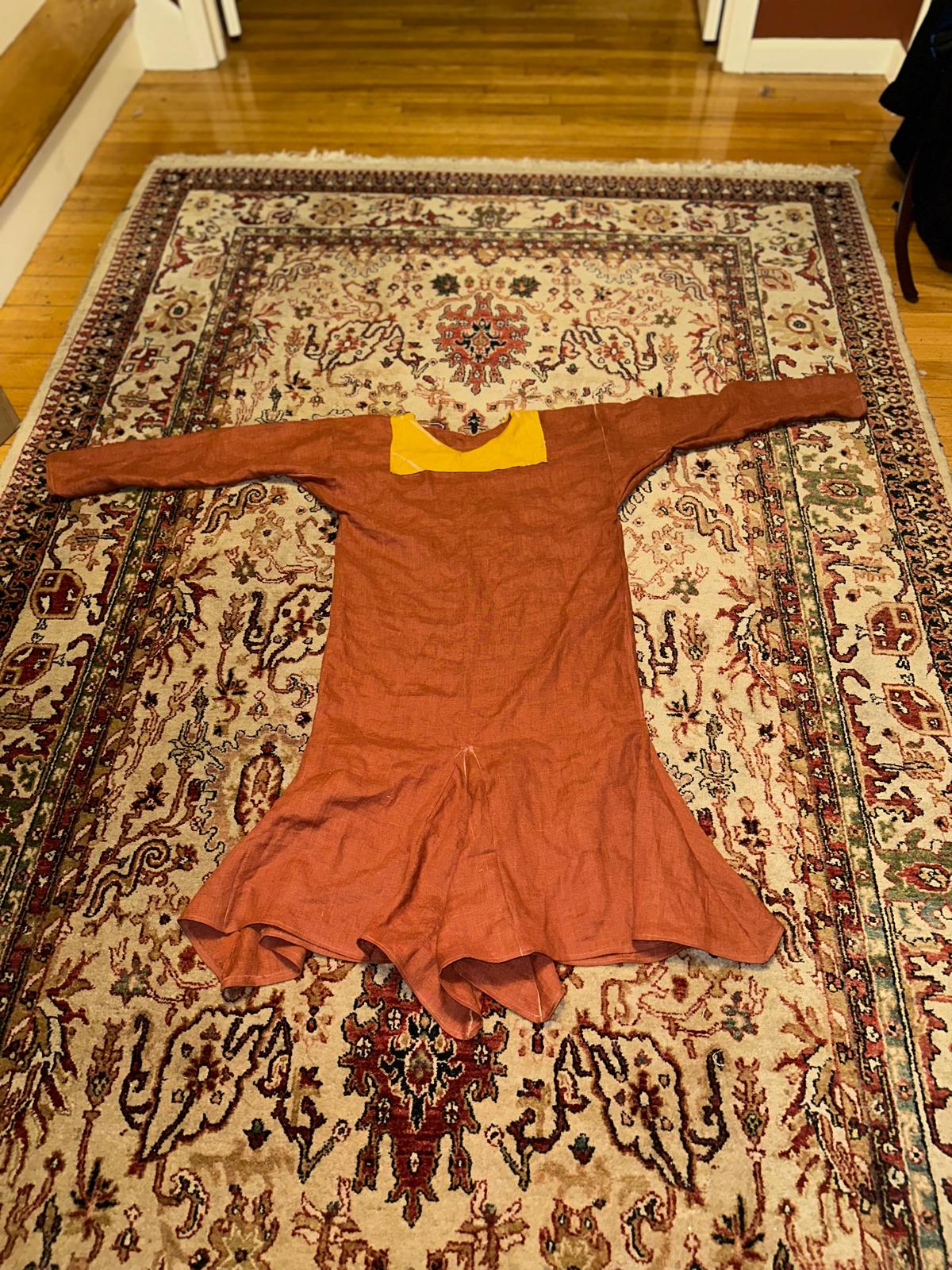 A brick-ish red tunic with a yellow collar in a Medieval style